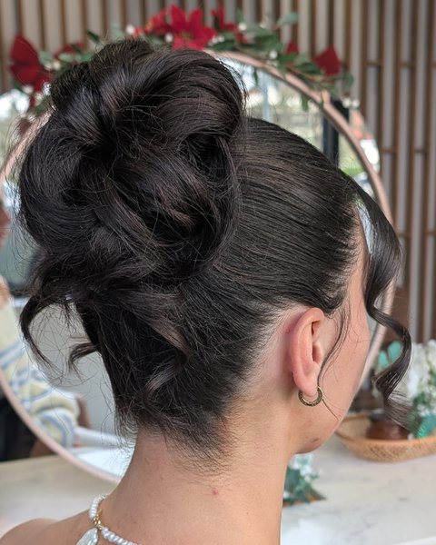 A formal upstyle: a twisted brunette bun with soft tendrils, done in the salon